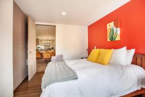 - une chambre avec un grand lit et un mur orange dans l'établissement Moderno Mexicano 3BR/2BA 200Mbps, à Mexico