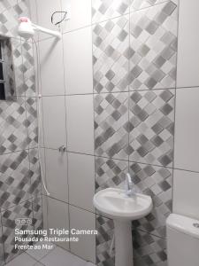 a bathroom with a shower and a sink and a toilet at Pousada e Restaurante Frente ao Mar in Cananéia