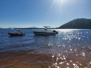 um barco e uma jangada na água em Pousada e Restaurante Frente ao Mar em Cananeia