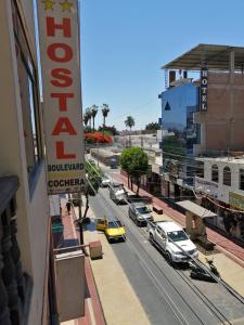 a city street with cars and a yellow taxi at Hostal Boulevard in Nazca