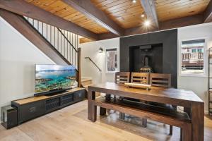 een woonkamer met een tafel en een televisie bij Cobalt Cabin - Beautifully remodeled 3BR with private hot tub, fireplace and dogs ok in Carnelian Bay