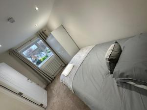 a bedroom with a large bed and a window at 5 bedroom house in Orpington in Orpington
