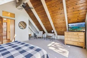 an attic bedroom with a wooden ceiling and a bed at Cedar Chalet by Tahoe Getaways - Stunning 3BR with Fireplace & Pet Friendly in Tahoe Vista +15 photos