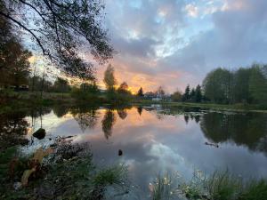 a view of a lake with the sunset in the background at Odpocznij in Dąbrówka