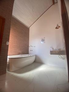 a white bathroom with a tub and a sink at Pousada Estância da Pinha in Santo Antônio do Pinhal