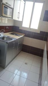 a kitchen with a sink and two windows at Jeddah Shadows Hotel in Jeddah