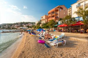 a beach with a bunch of chairs and people on it at Butique Maris in Komarna