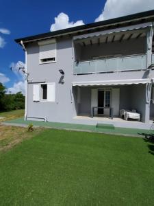 a white house with a lawn in front of it at Superbe appartement avec parking gratuit in Sainte-Anne