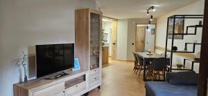 uma sala de estar com televisão e uma sala de jantar em Apartamento Baqueira pie pistas cota 1500 em Baqueira-Beret