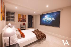 a bedroom with a large tv on the wall at Velvet Apartments - 10 Park Square East in Leeds