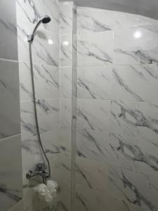 uma casa de banho com chuveiro e paredes em mármore branco em Appartement au centre ville de fès em Fez