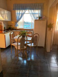 a kitchen with a table and chairs and a window at Espaço familiar aconchegante in Barbacena