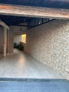 an empty room with a brick wall and a patio at Espaço familiar aconchegante in Barbacena
