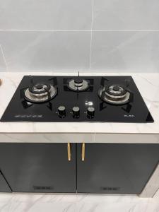 - une cuisine blanche équipée de plaques de cuisson noires dans l'établissement THE 99 SUITES, à Kuala Terengganu