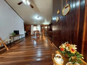 a living room with wooden floors and a table with flowers at La esquina in Dos de Mayo