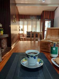 eine Tasse Kaffee auf einem Tisch mit einem Teller in der Unterkunft La esquina in Dos de Mayo