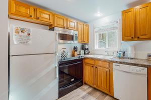 una cucina con frigorifero bianco e armadietti in legno di Alder Creek A-Frame a Sandy