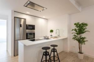 uma cozinha com um balcão com bancos e um frigorífico em Ap. Marbella centro em Marbella