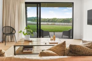 ケンブリッジにあるLakeSide Karapiro Downstairs Apartmentのソファとテーブルのあるリビングルーム