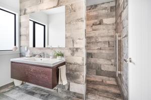 ケンブリッジにあるLakeSide Karapiro Downstairs Apartmentのレンガの壁、洗面台付きのバスルーム +16枚の写真