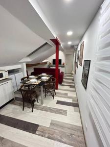 Il comprend un salon avec une table à manger et une cuisine. dans l'établissement Mansarda in pieno centro, à Savone
