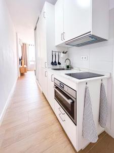 una cucina bianca con lavandino e piano cottura di Nature Apartment a Torremolinos