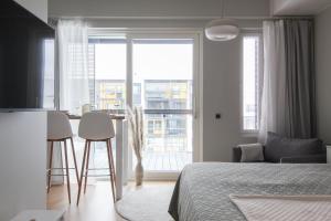 a bedroom with a bed and a table with chairs at City Apartment Kallaveden Marina in Kuopio