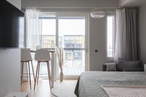 a bedroom with a bed and a table with chairs at Pramea Apartments Marina in Kuopio