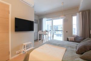 a bedroom with a bed and a tv on a wall at City Apartment Kallaveden Marina in Kuopio