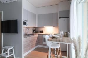 a kitchen with white cabinets and a table with chairs at City Apartment Kallaveden Marina in Kuopio