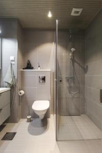 a bathroom with a shower stall and a toilet at Pramea Apartments Marina in Kuopio +18 photos