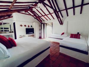 a bedroom with two white beds and a tv at Rancho Eden in Armenia