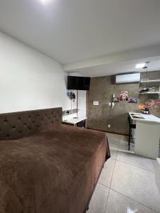 a bedroom with a large bed and a kitchen at STUDIO 304 | WIFI 600MB | RESIDENCIAL JC, um lugar para ficar. in Belém