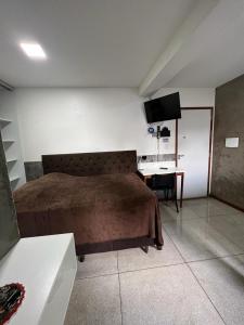 a bedroom with a bed and a desk in it at STUDIO 304 | WIFI 600MB | RESIDENCIAL JC, um lugar para ficar. in Belém