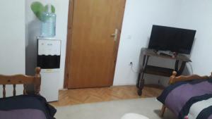 a room with a door and a desk with a television at Rooms Struga in Struga