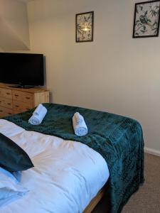 una camera da letto con un letto e pantofole di Woodland Green - BHX, NEC, HS2 a Marston Green