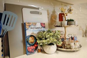 - un réfrigérateur avec des plantes et une pancarte sur un comptoir dans l'établissement Central Suite King Beds,Long Stays,Disney+, à Edmonton