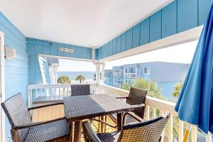 a table and chairs on a balcony with the ocean at Sight of the Sea in Myrtle Beach