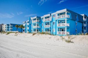 a blue building on the beach next to the sand at Sight of the Sea in Myrtle Beach