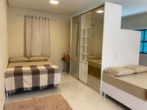 a bedroom with two beds and a mirror at Sítio Casa Vida Nova in Itacaré