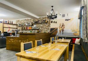 a restaurant with two wooden tables and a bar at Hotel Hejtmanka in Mladá Boleslav