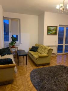 a living room with two couches and a table at Central Apartament Dworskiego in Przemyśl