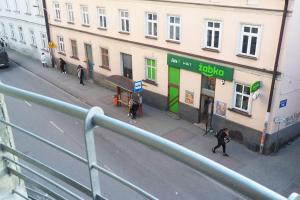 Un grupo de personas caminando por una calle al lado de un edificio. en Central Rooms, en Przemyśl