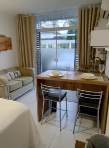 sala de estar con mesa y 2 sillas en Loft / Studio Privativo com Estacionamento, en Florianópolis