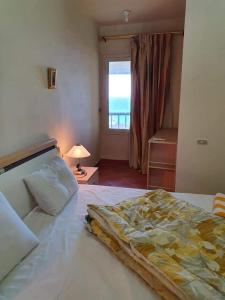 1 dormitorio con 1 cama grande y ventana en Porto sokhna pyramids family only en Ain Sokhna