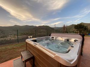 a jacuzzi tub on a deck with mountains in the background at La Casa del Valle in Santa Cruz de Tenerife