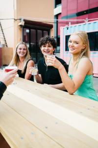 un grupo de personas sentadas en una mesa bebiendo vino en The Village Surry Hills, en Sídney
