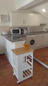 a kitchen with white cabinets and a counter top at Musa Mar studio with balcony panoramic view in the residential area in Quarteira