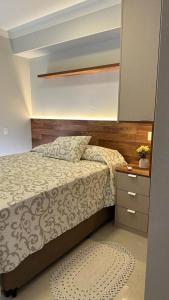a bedroom with a bed and a dresser with a mirror at Residencial Legend in Santos