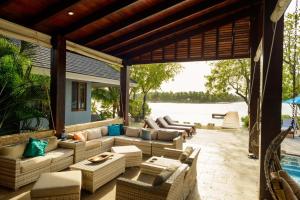 an outdoor patio with couches and chairs and a pool at The Enclave - Your Own Private Island Retreat in Placencia Village